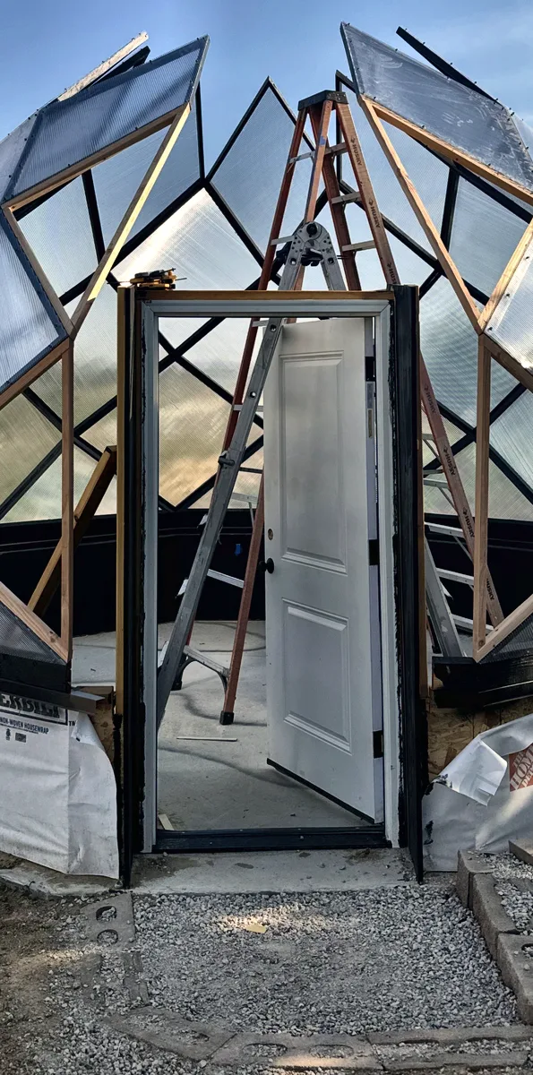 The door being framed into the zome during the build, with polycarbonate panels going on around it.